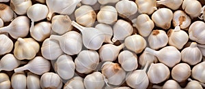 A stack of garlic bulbs on a wooden table, closeup view