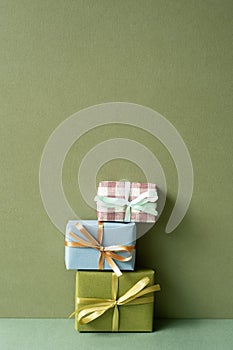 Stack of gift box on green table. khaki wall background. anniversary celebration concept