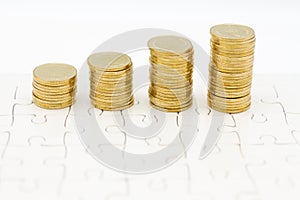 Stack of golden coins on jigsaw board. Image use for investment, business background concept