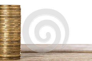 Stack of golden coins on wooden table, space for text