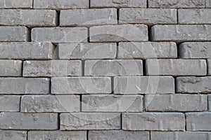 A stack of gray fluted bricks laid in rows, which are intended for paving roads and sidewalks.