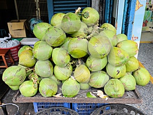 Stack of green coconuts on a rustic improvised table