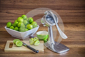 Stack of green lemon with aluminum manual juicer squeezer fruit