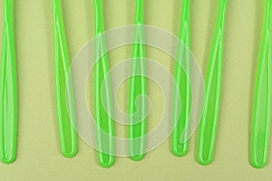 stack of green plastic forks on a green background