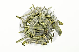 A stack of green tea leaves with tips on a white background