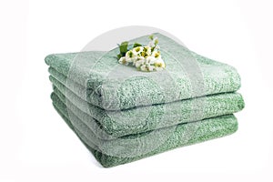 Stack of green, terry, bath towels isolated on white background