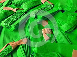 stack of green tote bags tied with light brown string.