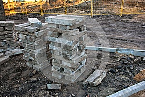 Stack of grey concrete curbs on construction site