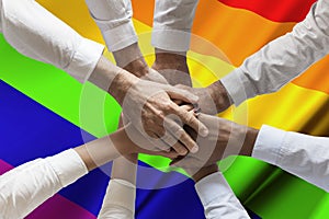 Stack of hands team over Rainbow or peace or gay flag waving