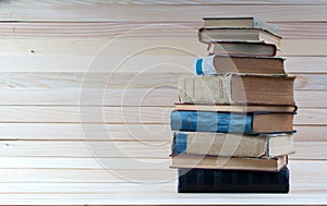 Stack of hardback books on wooden table. Back to school.