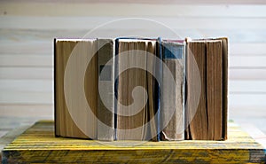 Stack of hardback books on wooden table. Back to school.