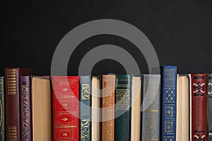 Stack of hardcover books on black. Space for text