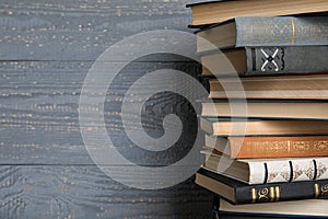 Stack of hardcover books on grey wooden background