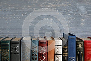 Stack of hardcover books on grey wooden background