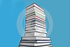 Stack of hardcover books on light blue background