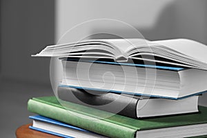 Stack of hardcover books on wooden table, closeup