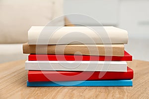 Stack of hardcover books on wooden table indoors