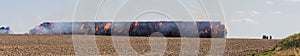 Stack hay in fire on field with firemans