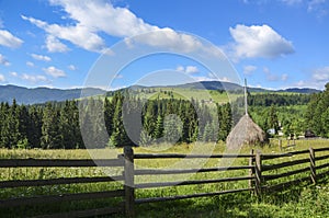 Stack of hay on a mountain meadow on a hillside