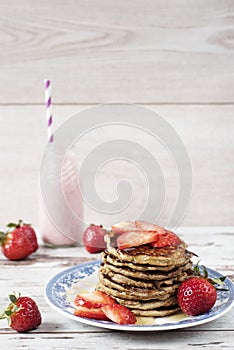 Stack of healthy low carbs oat and banana pancakes over white wooden background