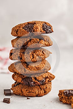 Stack of healthy vegan cookies with chocolate, white background.