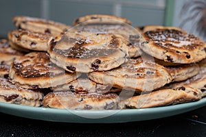 Stack of Homemade Welsh Cakes Bakestones freshly cooked on a green plate