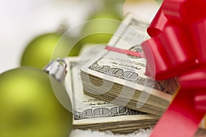 Stack of Hundred Dollar Bills with Bow Near Christmas Ornaments