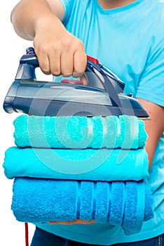 a stack of ironed terry towels and an iron in male hands