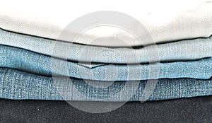 stack of jeans folded on white background
