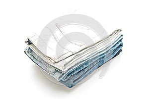 stack of jeans folded on white background