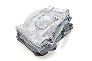 stack of jeans folded on white background