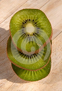 Stack of kiwi slices on a wooden board