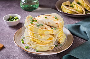 A stack of Kystyby - thin flatbread filled with mashed potatoes and onions on a plate