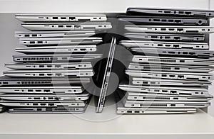 Stack of laptops in the storage room of a company