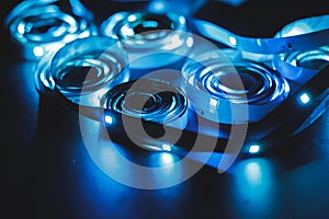 A stack of LED lights on coiled flexible lighting strips, colored blue