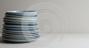 A stack of light blue ceramic bowls and plates is neatly arranged on a light-colored