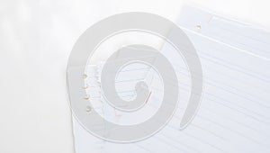 Stack of Lined Notebook Paper Sheets on White Surface for Writing and Notes