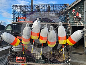 A stack of lobster traps with buoys in front of a lobster shack in Maine, USA in summer