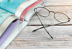 Stack magazines with glasses on wooden table