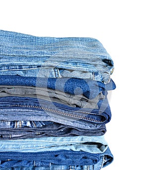 Stack on many jeans isolated on white close-up