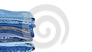 Stack on many jeans isolated on white close-up