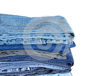Stack on many jeans isolated on white close-up