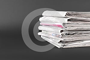 Stack of many newspapers on grey background, space for text