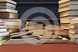 A stack of many old books on the table-background of bookshelve