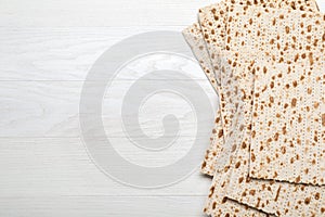 Stack of matzos on white wooden table, flat lay. Space for text