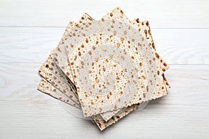 Stack of matzos on white wooden table, top view