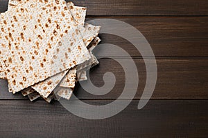 Stack of matzos on wooden table, top view. Space for text