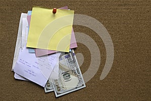 A stack of memo notes with payment receipt and dollar bill on notice cork board. Copy space for text, logo