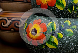 Stack of Mexican ceramic pots, grey background, orange flowers