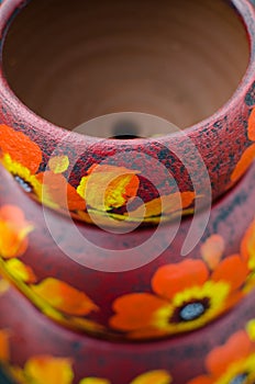 Stack of Mexican ceramic pots, purple background, orange flowers